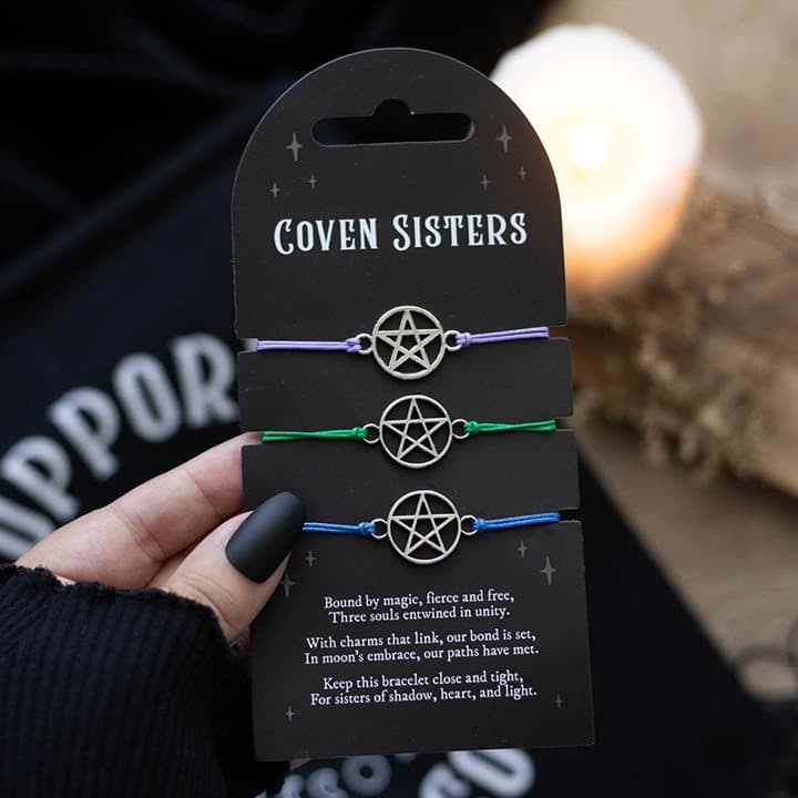 Set of three string bracelets with metal pentagram charms on a backing card