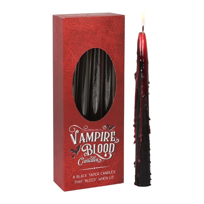 Black and red taper candles with bleeding wax effect in a window box