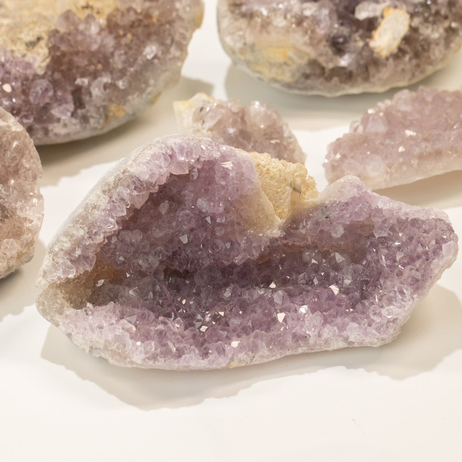 Assorted small opened amethyst geodes showing purple crystal inside