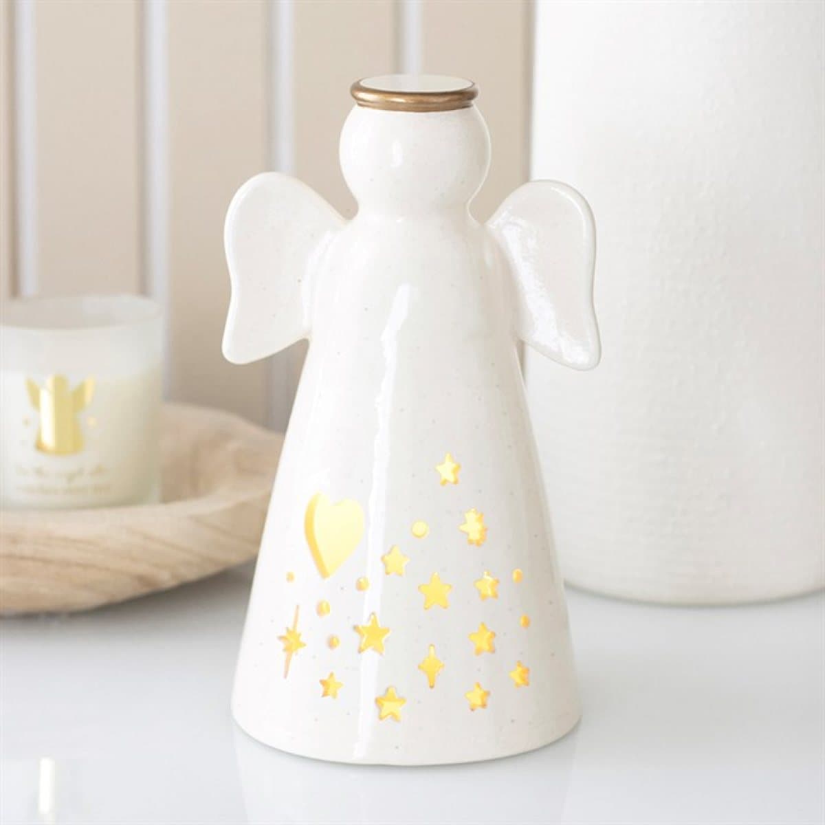 Small off-white ceramic angel with a gold halo and heart and star cut-outs