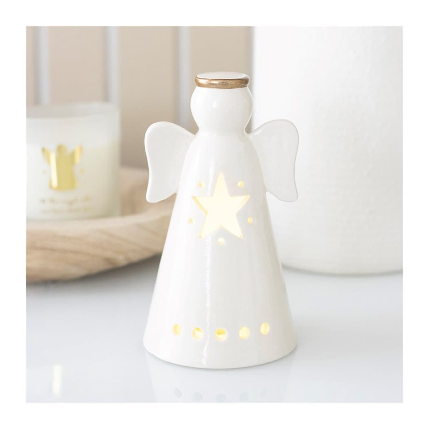 Small white ceramic angel with wings and a star-shaped cut-out