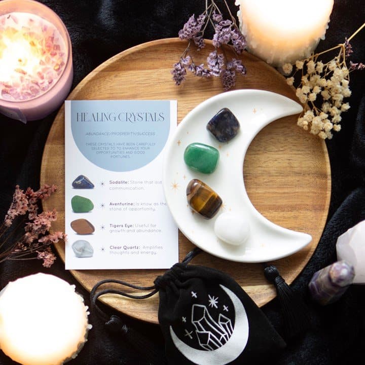 Four tumble stones with a crescent moon trinket dish and information card