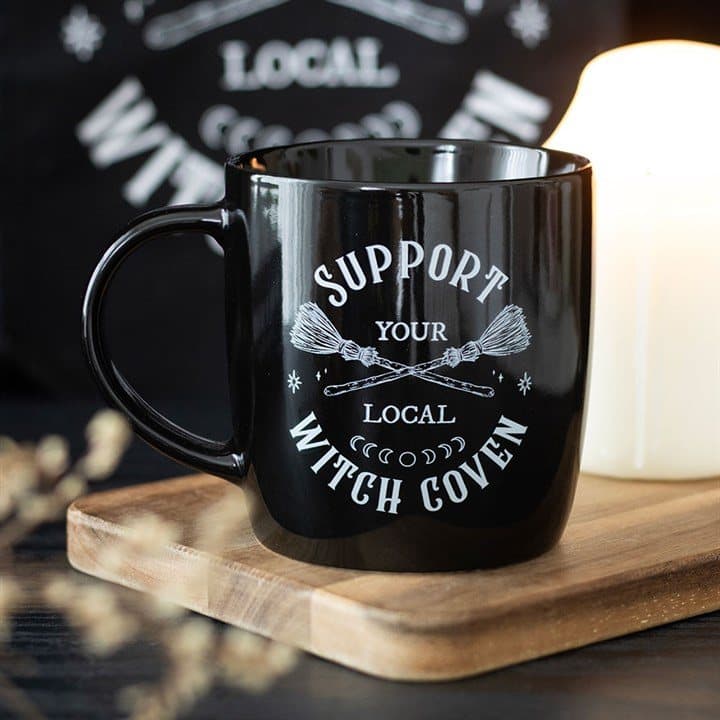 Black ceramic mug with crossed broomsticks and witch coven slogan