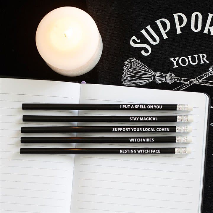 Five black witchy pencils with mystical phrases in purple striped packaging