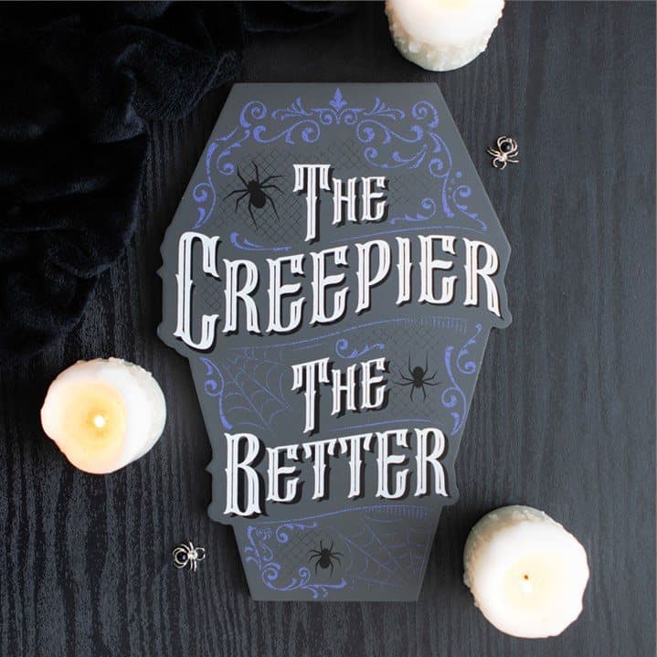 Muted grey coffin shaped sign reading The Creepier the Better