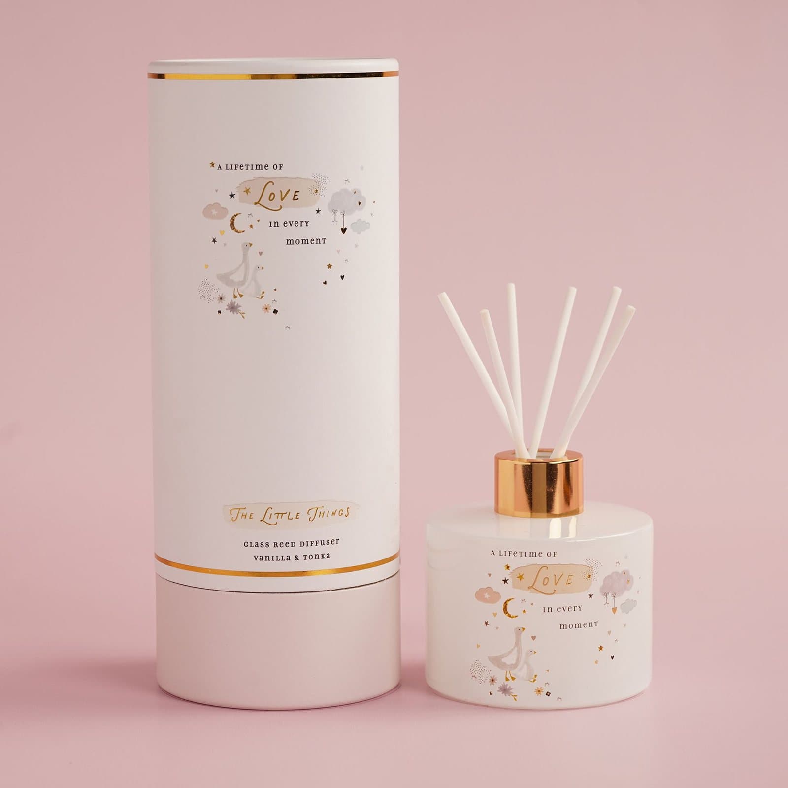Glass reed diffuser with a love message beside its cylindrical gift box