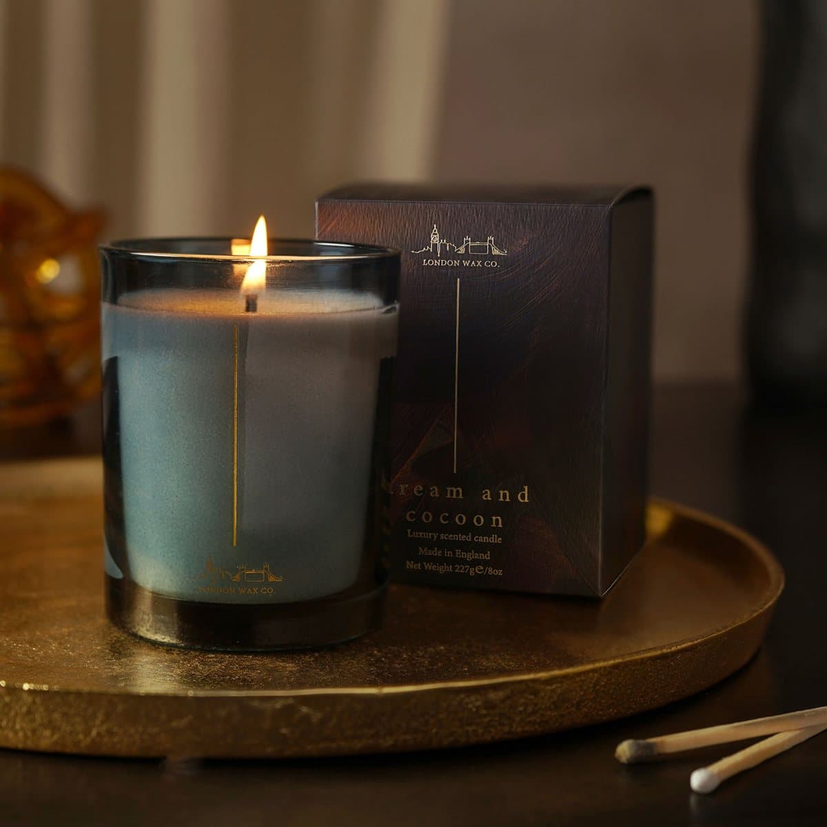 Dream & Cocoon candle in a glass container with its sleek black box