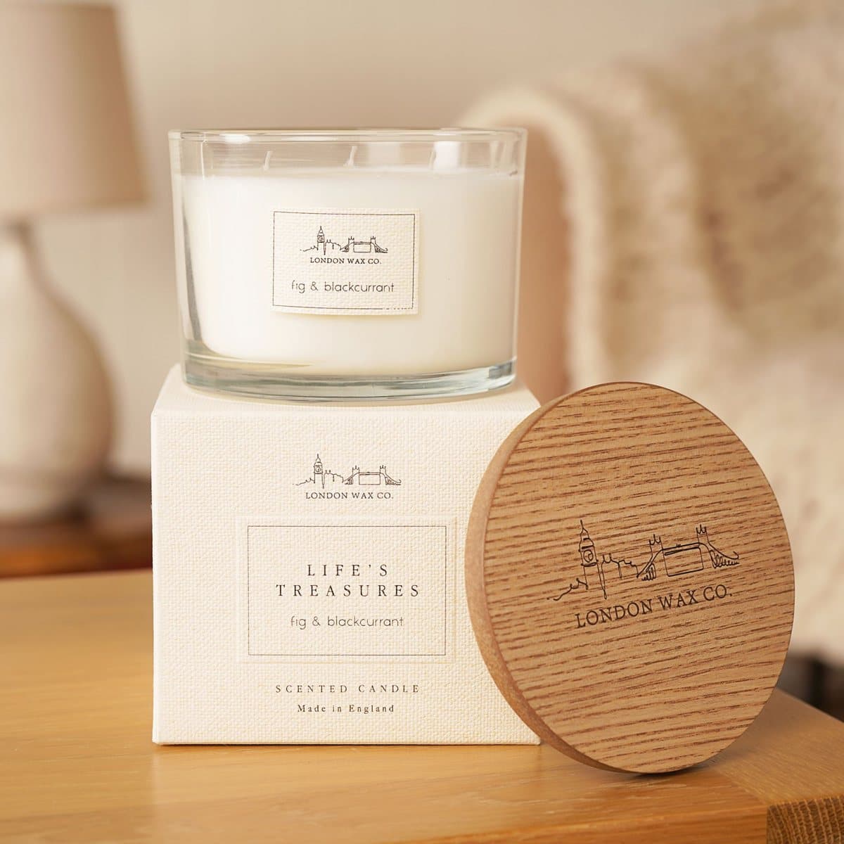 Fig & Blackcurrant scented candle in a clear glass jar with a wooden lid