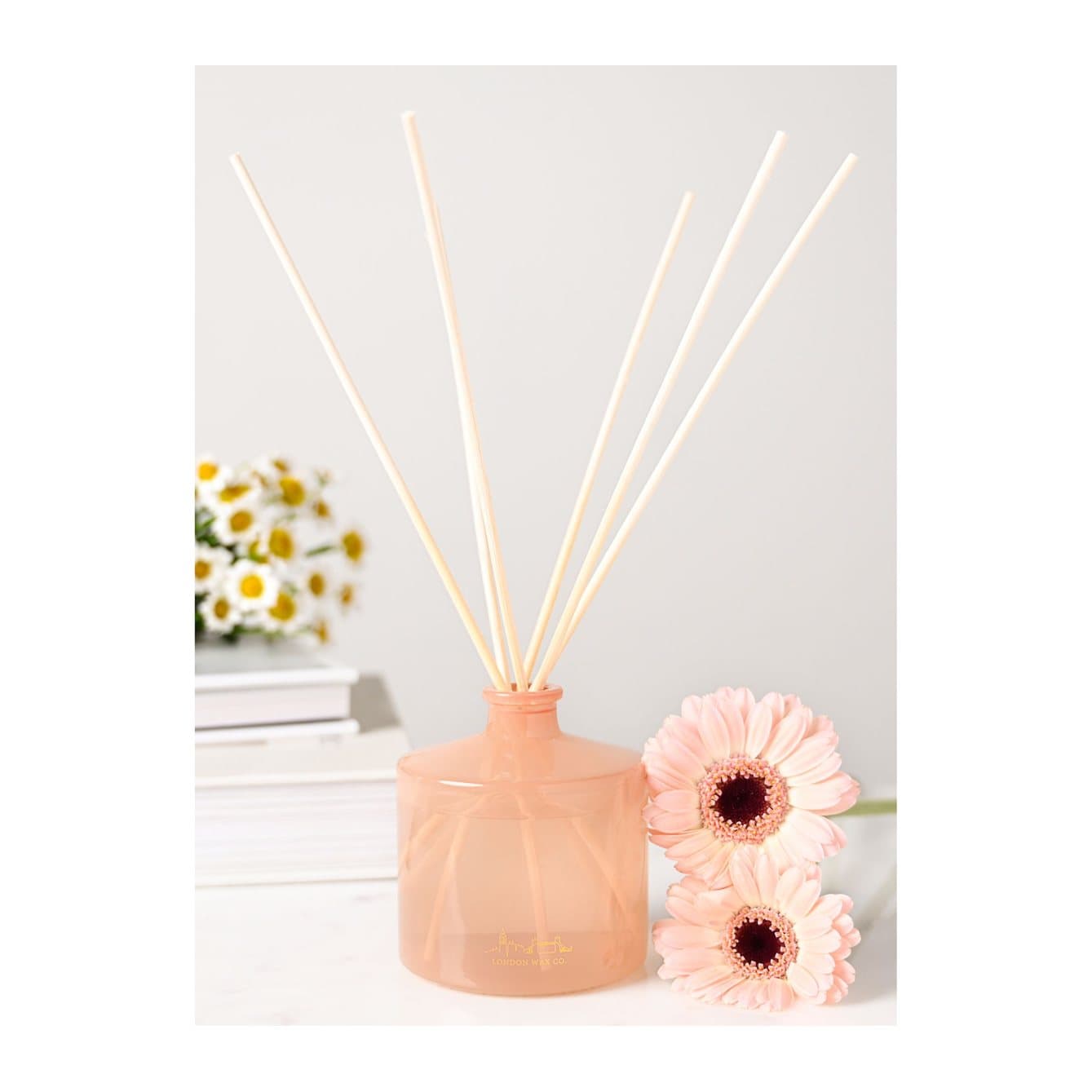 Meadow Dance glass reed diffuser bottle with wooden reeds beside its floral box