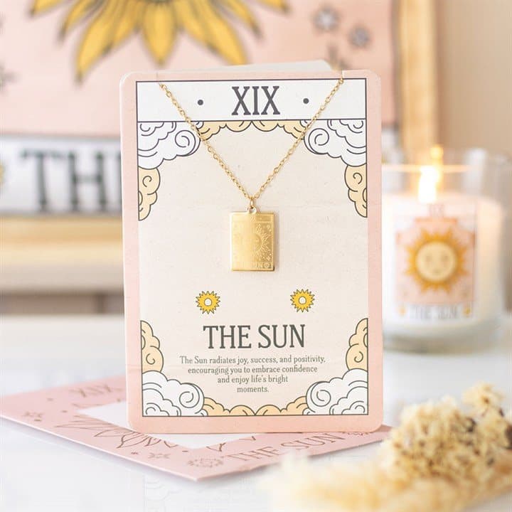 Gold-toned The Sun tarot pendant necklace on a greeting card