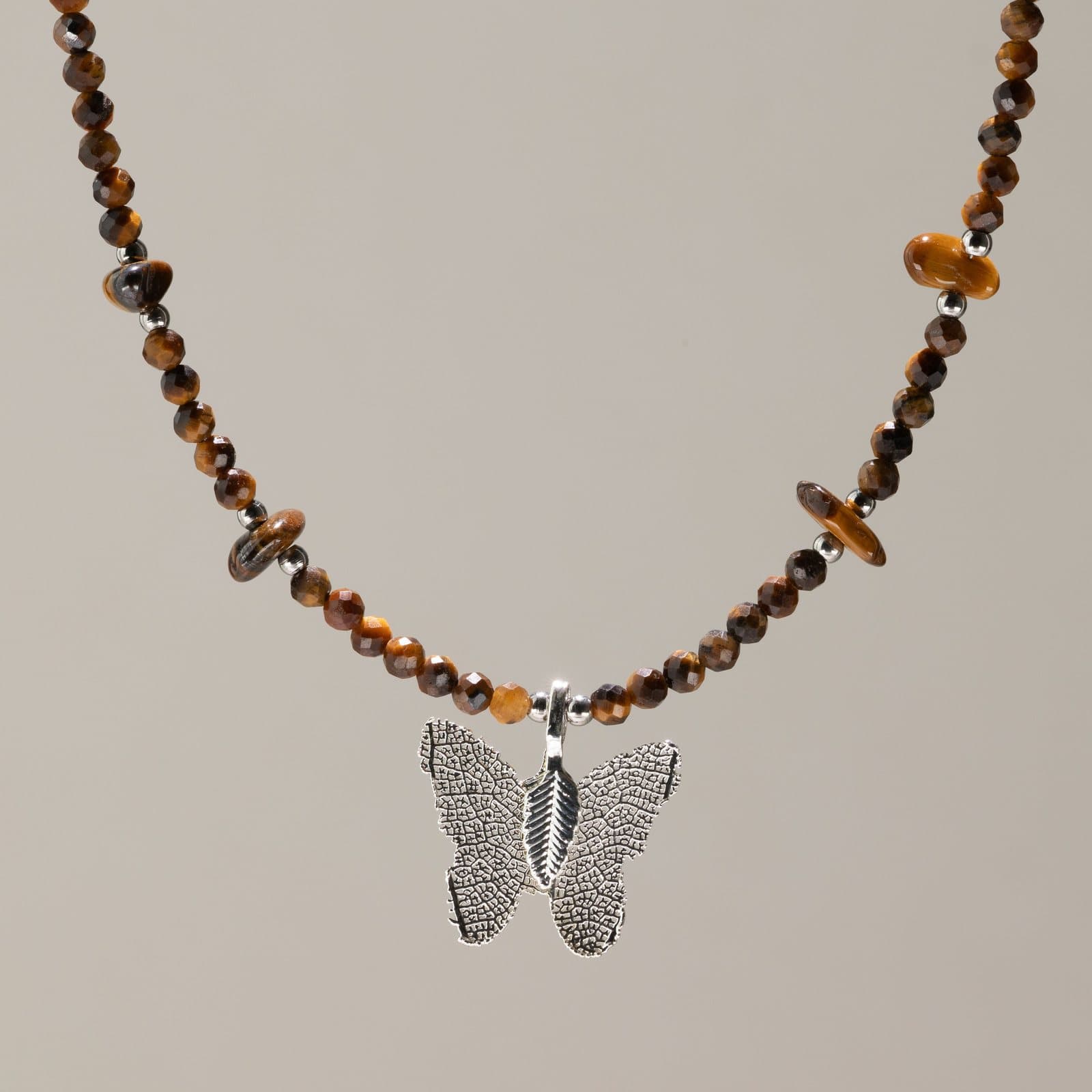 Faceted tiger's eye bead necklace with a silver-plated leaf butterfly pendant