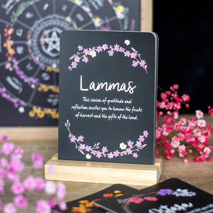 Illustrated Wheel of the Year sabbat card on a natural wooden stand