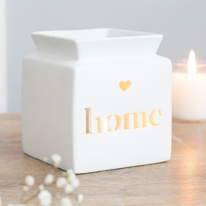 White ceramic oil burner with a cutout heart and the word home