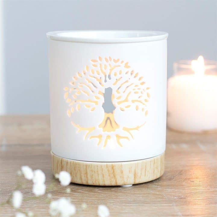 White ceramic oil burner with a cutout Tree of Life design and wood-effect base