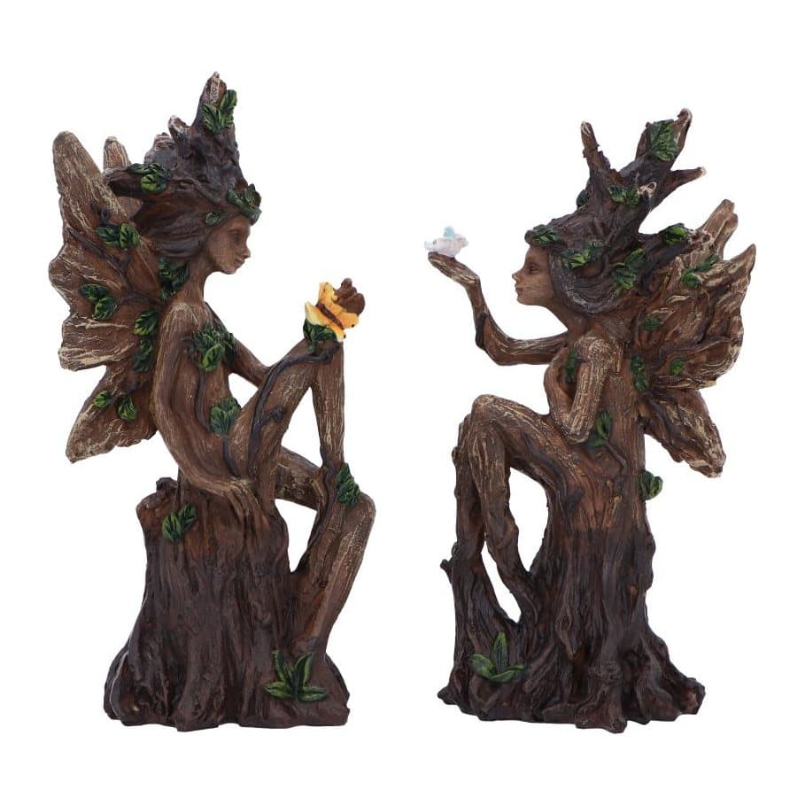 Two wood-like tree fairy figurines embracing on a tree stump